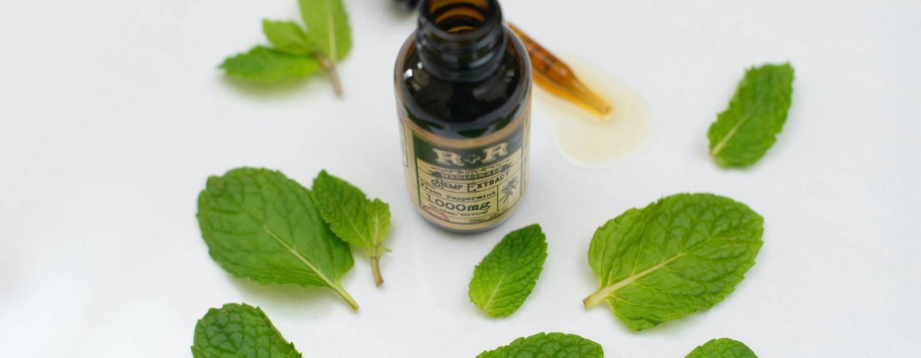 Frische Pfefferminzblätter mit Braunglasflasche – natürliche Tinktur für Gesundheit und Wohlbefinden.