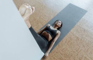 Frau in der Übung Beine an der Wand – entspannende Haltung im Yoga zum Schlafen zur Beruhigung und Regeneration