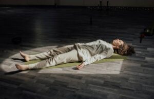 Frau in Savasana – beruhigende Endentspannung im Yoga zum Schlafen mit Fokus auf Loslassen und innere Ruhe