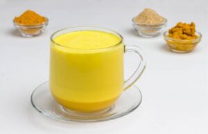 Eine Tasse goldene Milch mit Kurkuma, Ingwer und Gewürzen - ein beruhigendes Abendritual zum Immunsystem stärken pflanzlich.