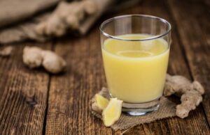 Immunsystem stärken pflanzlich: Frischer Ingwer-Zitronen-Shot in einem kleinen Glas mit Ingwerwurzel im Hintergrund