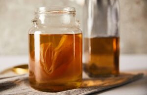 Immunsystem stärken pflanzlich - Glas Kombucha mit fermentiertem Tee und Hefe-Kultur auf einem hellen Tisch – natürlicher Helfer für die Darmgesundheit.