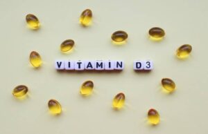 Vitamin D3 Kapseln auf gelbem Hintergrund – Nahrungsergänzung gegen Müdigkeit im Winter